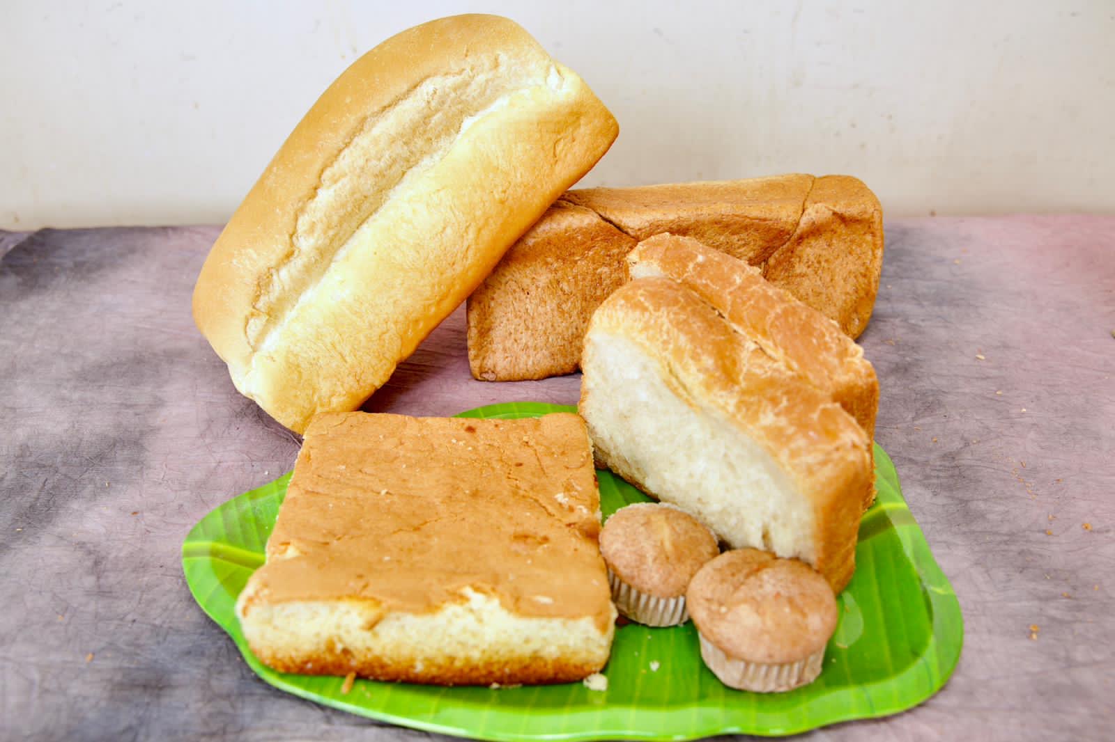 Bakery loaf, roast paan, cup cakes and butter cake arranged together