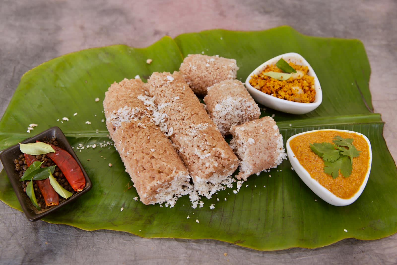 Steamed puttu served with coconut chutney and sambal